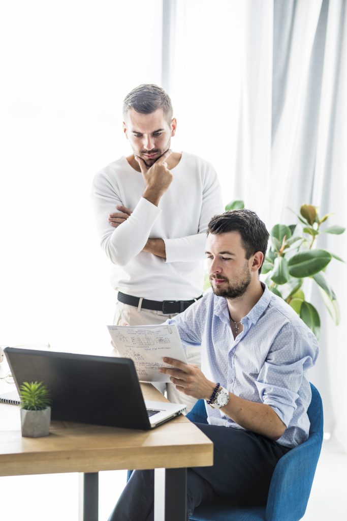 two male businessmen working office Comunicação Acolhedora no RH: Engajando Equipes 